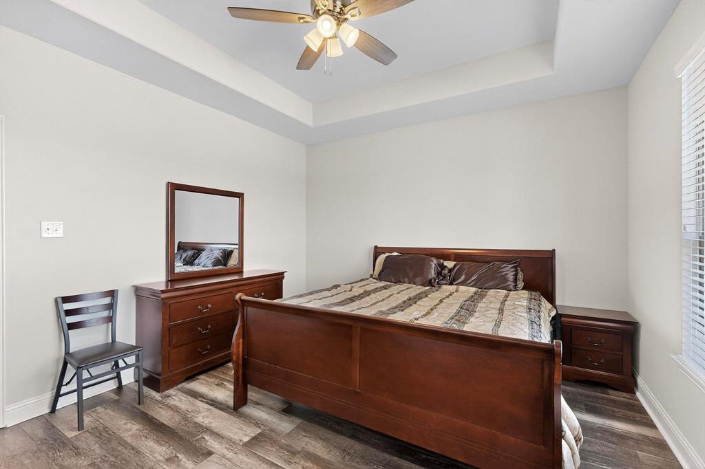 634 Gant Road Sherman, TX 75090 - Photo 12 of 40 Spacious room featuring tray ceiling, wood-finish flooring, ceiling fan with light kit, and natural light from a window with blinds