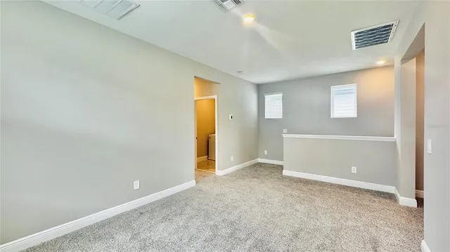 an empty room with closet and windows