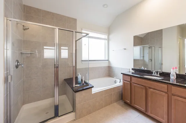 a bathroom with a tub sink shower and mirror