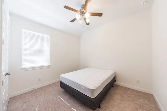 a bedroom with a bed and a ceiling fan