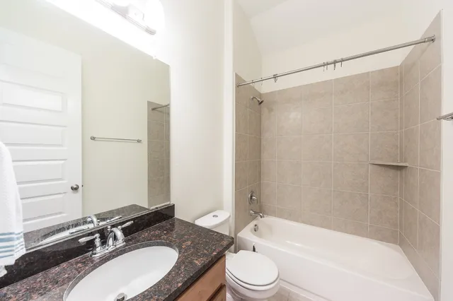 a bathroom with a granite countertop sink toilet and shower