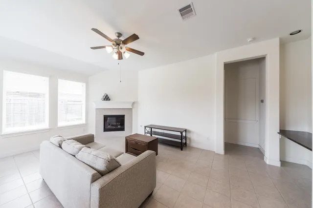 a living room with furniture a fireplace and a window