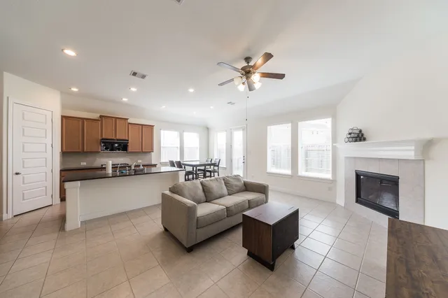 a living room with furniture fireplace and kitchen view