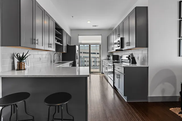 a kitchen with stainless steel appliances granite countertop a sink a stove and a refrigerator