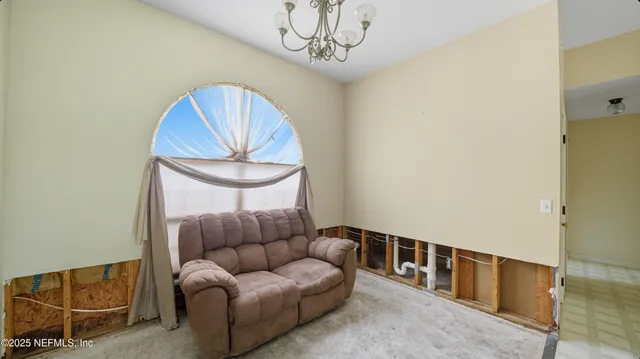a living room with furniture a chandelier and a rug