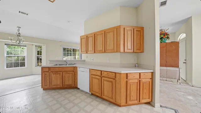 a kitchen with granite countertop a sink stove and cabinets