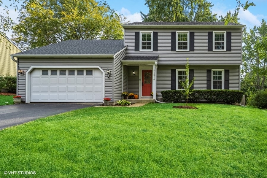 a front view of a house with a garden and yard