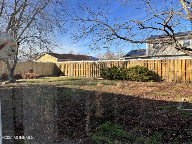 a view of a yard with plants and trees