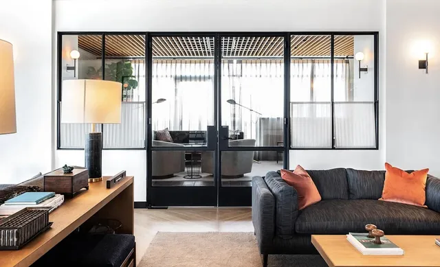 a living room with furniture and a floor to ceiling window