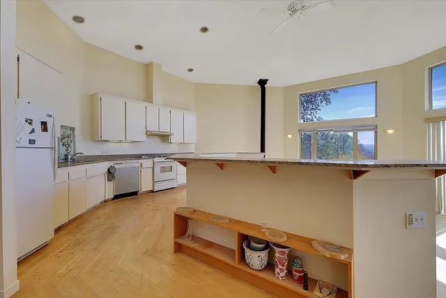 a kitchen with granite countertop white cabinets and white appliances