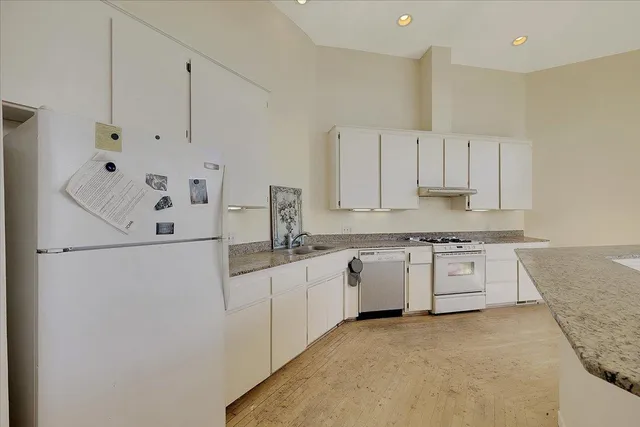 a bathroom with a granite countertop sink mirror vanity and toilet