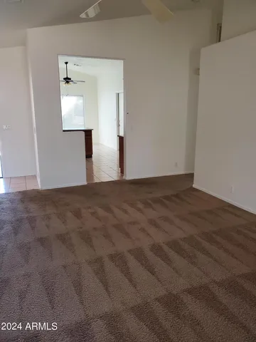 a view of an empty room with wooden floor and mirror
