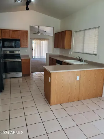 a kitchen with kitchen island granite countertop a stove a sink and a refrigerator