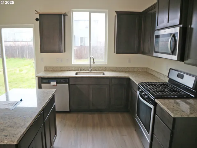 a kitchen with a sink stove top oven and cabinets