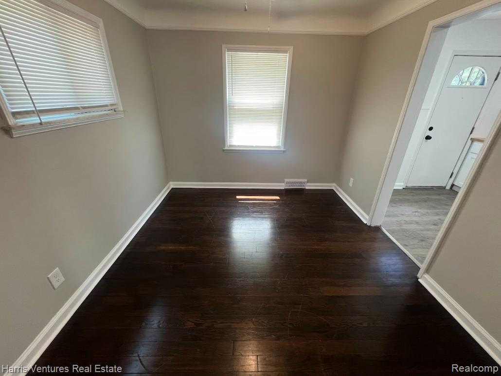 22148 Moross Road Grosse Pointe, MI 48236 - Photo 9 of 16 Room featuring dark wood-finish flooring, light neutral wall paint, and white trim