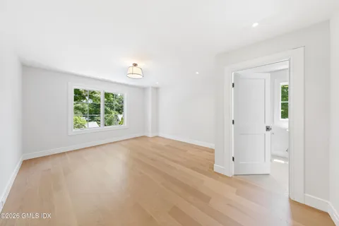 an empty room with wooden floor and window
