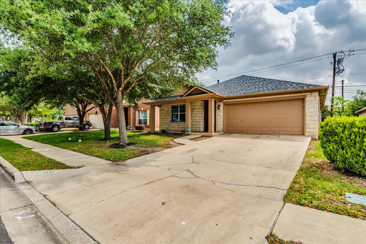 1151 Stone Rim Loop Buda, TX 78610 - Photo 32 of 35 The property features a concrete driveway leading to an attached two-car garage