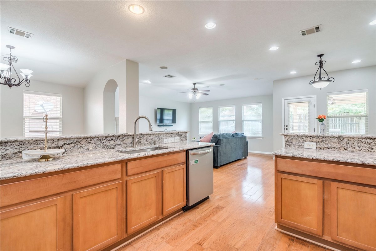 1151 Stone Rim Loop Buda, TX 78610 - Photo 9 of 35 Kitchen with granite countertops, breakfast bar, overlooking living room