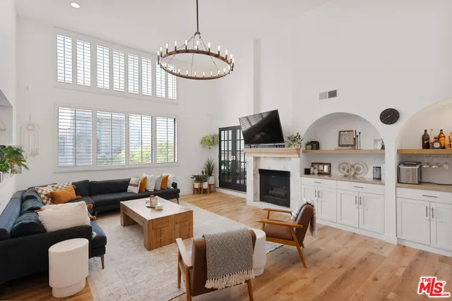 a living room with furniture a fireplace and a large window