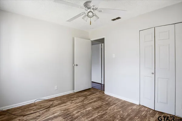 a view of room with hardwood floor and ceiling fan