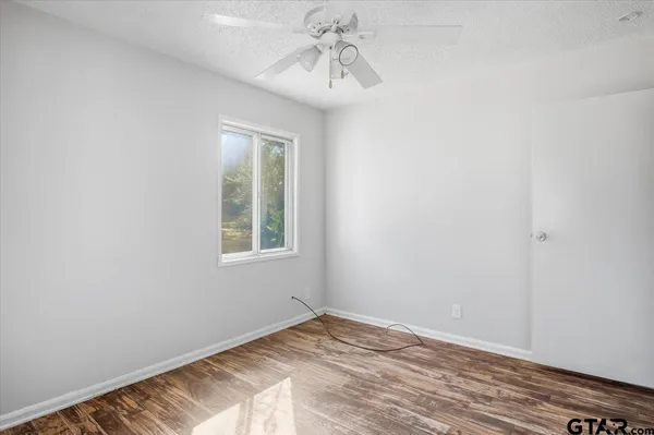 a view of empty room with window and wooden floor