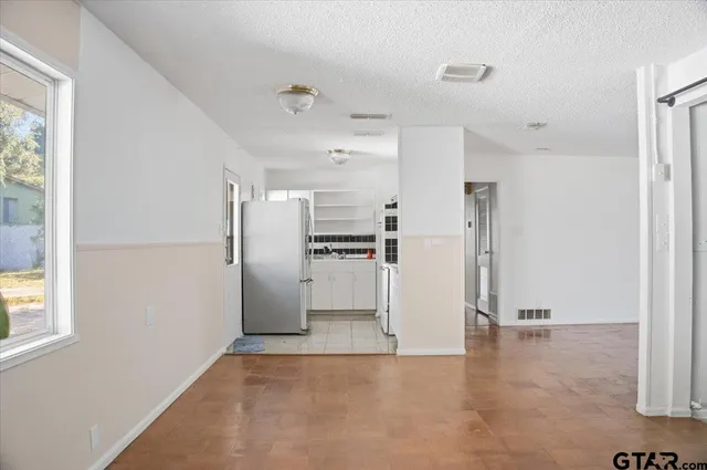 a view of kitchen with refrigerator and window