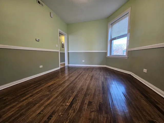 a view of a room with wooden floors and window