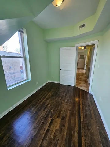 a view of a room with wooden floor and window