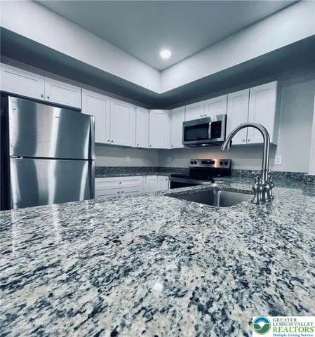 a kitchen with a refrigerator a stove a sink and a microwave