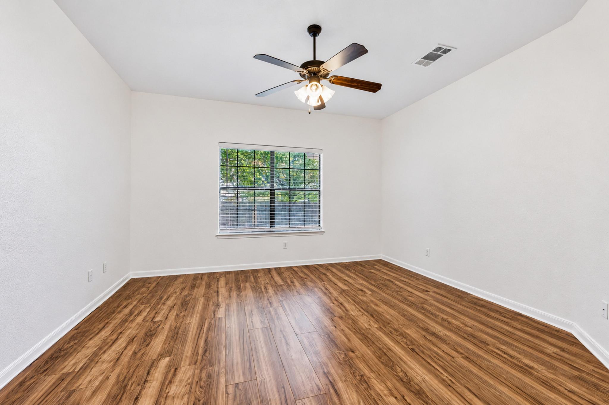 150 Engineers Pass Jarrell, TX 76537 - Photo 29 of 40 Rich wood-look flooring and a wide window create a comfortable, inviting secondary bedroom.