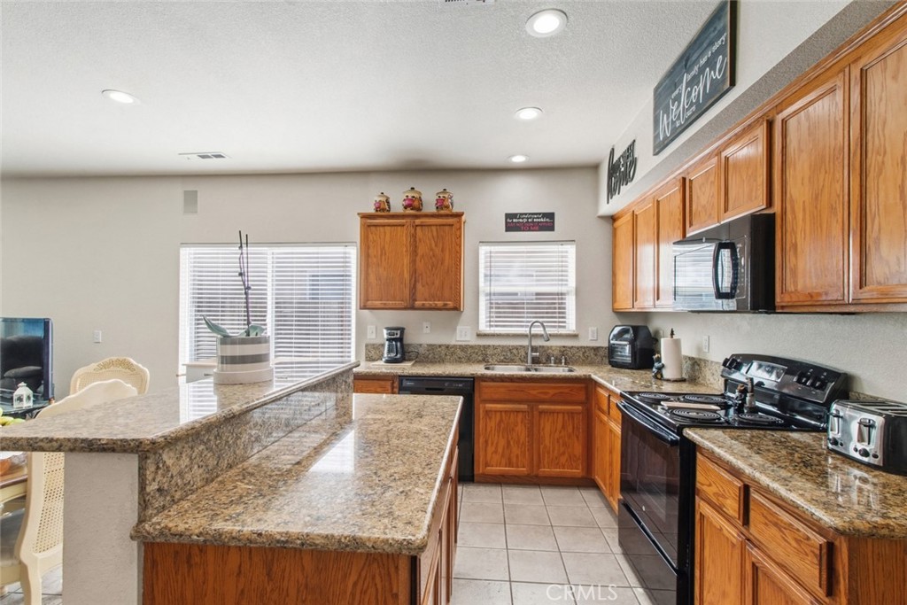 2408 Snap Dragon Court Modesto, CA 95355 - Photo 12 of 37 a kitchen with stainless steel appliances granite countertop a sink stove and cabinets