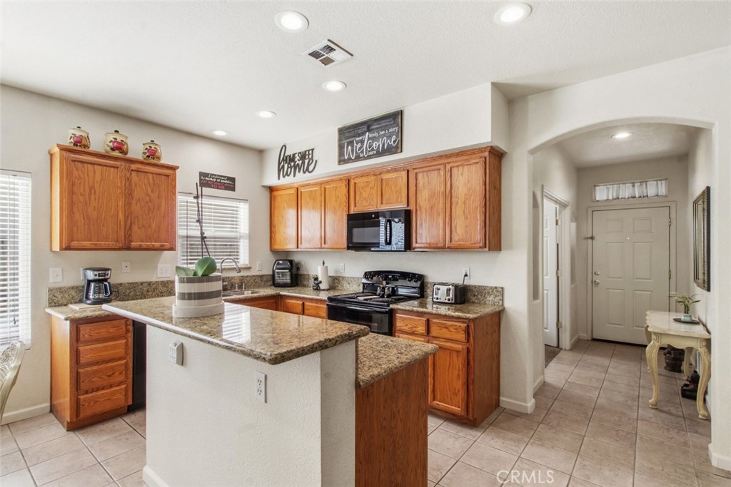 2408 Snap Dragon Court Modesto, CA 95355 - Photo 13 of 37 a kitchen with a sink a stove and cabinets
