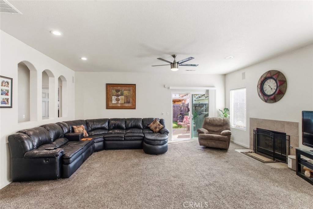 2408 Snap Dragon Court Modesto, CA 95355 - Photo 17 of 37 a living room with furniture a fireplace and a large mirror with wooden floor