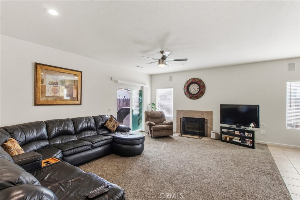 2408 Snap Dragon Court Modesto, CA 95355 - Photo 18 of 37 a living room with furniture a flat screen tv and a fireplace