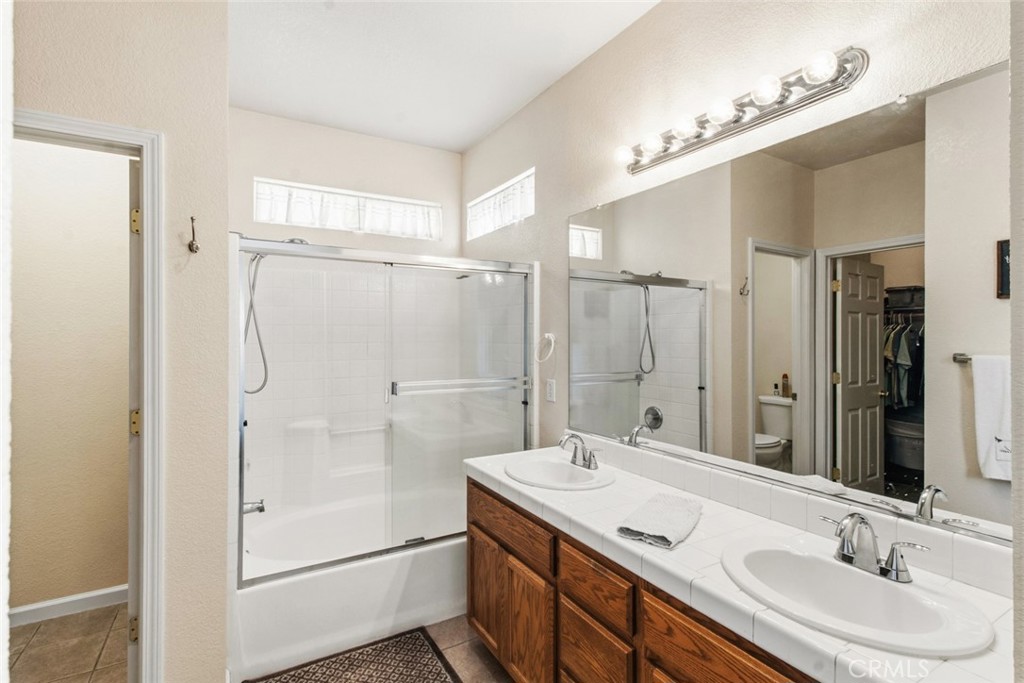 2408 Snap Dragon Court Modesto, CA 95355 - Photo 27 of 37 a bathroom with a granite countertop sink mirror shower and double