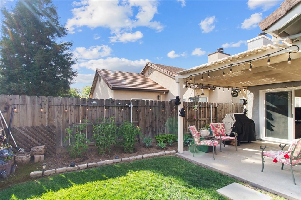 2408 Snap Dragon Court Modesto, CA 95355 - Photo 34 of 37 a view of a patio with table and chairs with wooden fence and plants