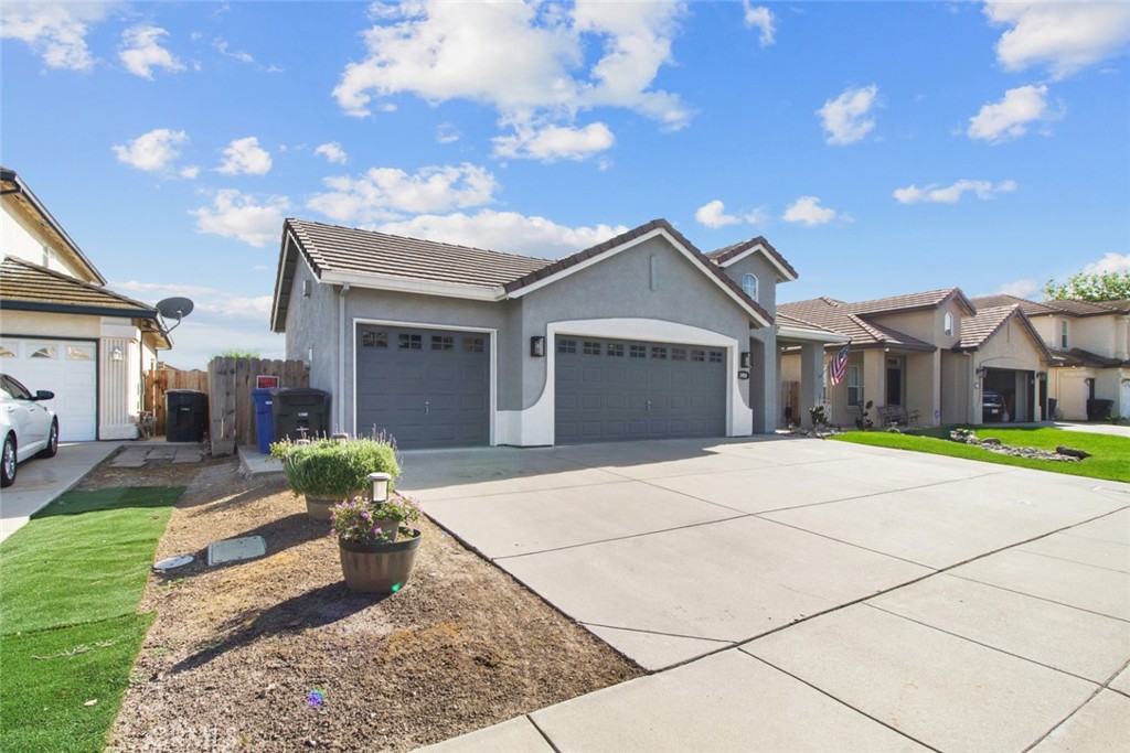 2408 Snap Dragon Court Modesto, CA 95355 - Photo 6 of 37 a front view of a house with a yard and potted plants