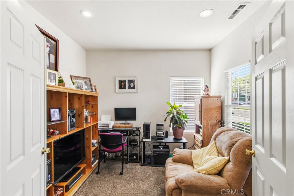 2408 Snap Dragon Court Modesto, CA 95355 - Photo 10 of 37 a living room with furniture a bookshelf and a flat screen tv