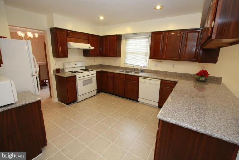 10 Autumn Ridge Court Silver Spring, MD 20906 - Photo 11 of 23 a kitchen with stainless steel appliances granite countertop a refrigerator sink stove microwave and cabinets
