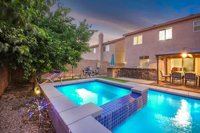 a view of a kitchen with a sink and dishwasher a barbeque with potted plants