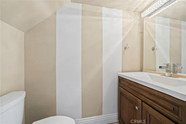 a bathroom with a sink a toilet a mirror and shower