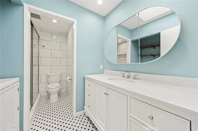 a bathroom with a sink a toilet and a mirror