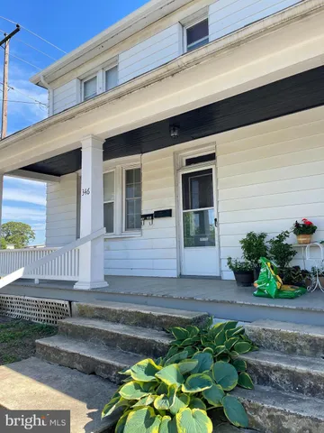 a front view of a house with potted plants