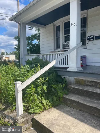 a view of small house with a yard and wooden fence