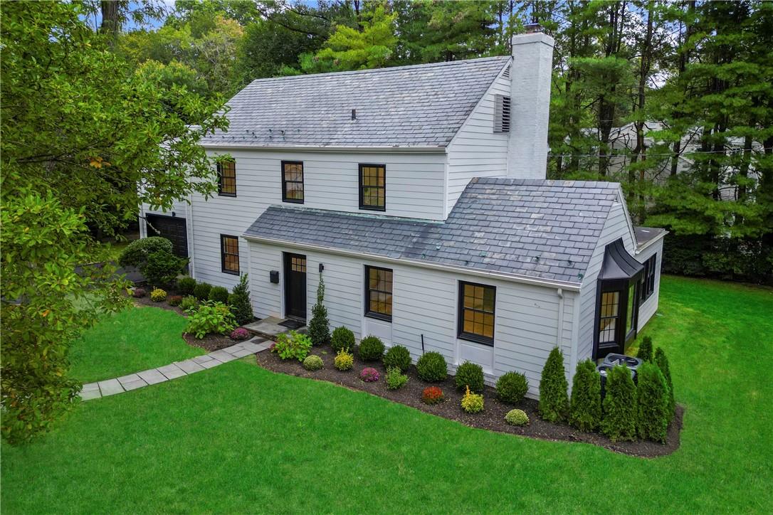 a aerial view of a house with a yard potted plants and large tree