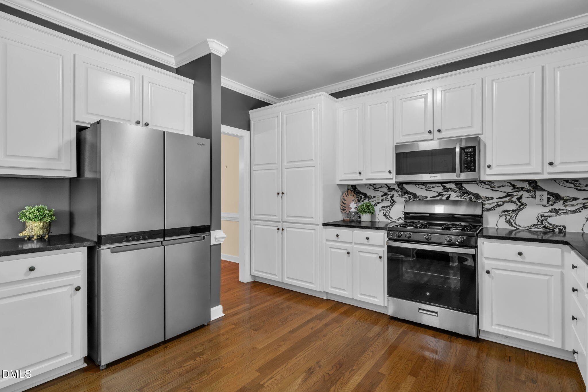 5309 Shoreline Court Holly Springs, NC 27540 - Photo 12 of 46 a kitchen with a refrigerator stove and white cabinets