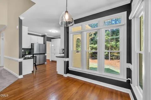 a open kitchen with stainless steel appliances granite countertop a refrigerator oven stove a island and couches with wooden floor