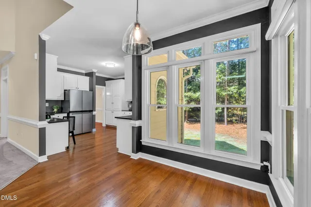 a open kitchen with stainless steel appliances granite countertop a refrigerator oven stove a island and couches with wooden floor