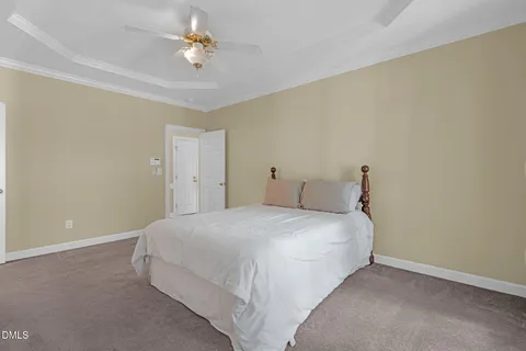 a bedroom with a bed and a ceiling fan
