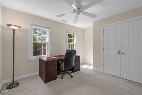a view of a workspace with furniture and a window